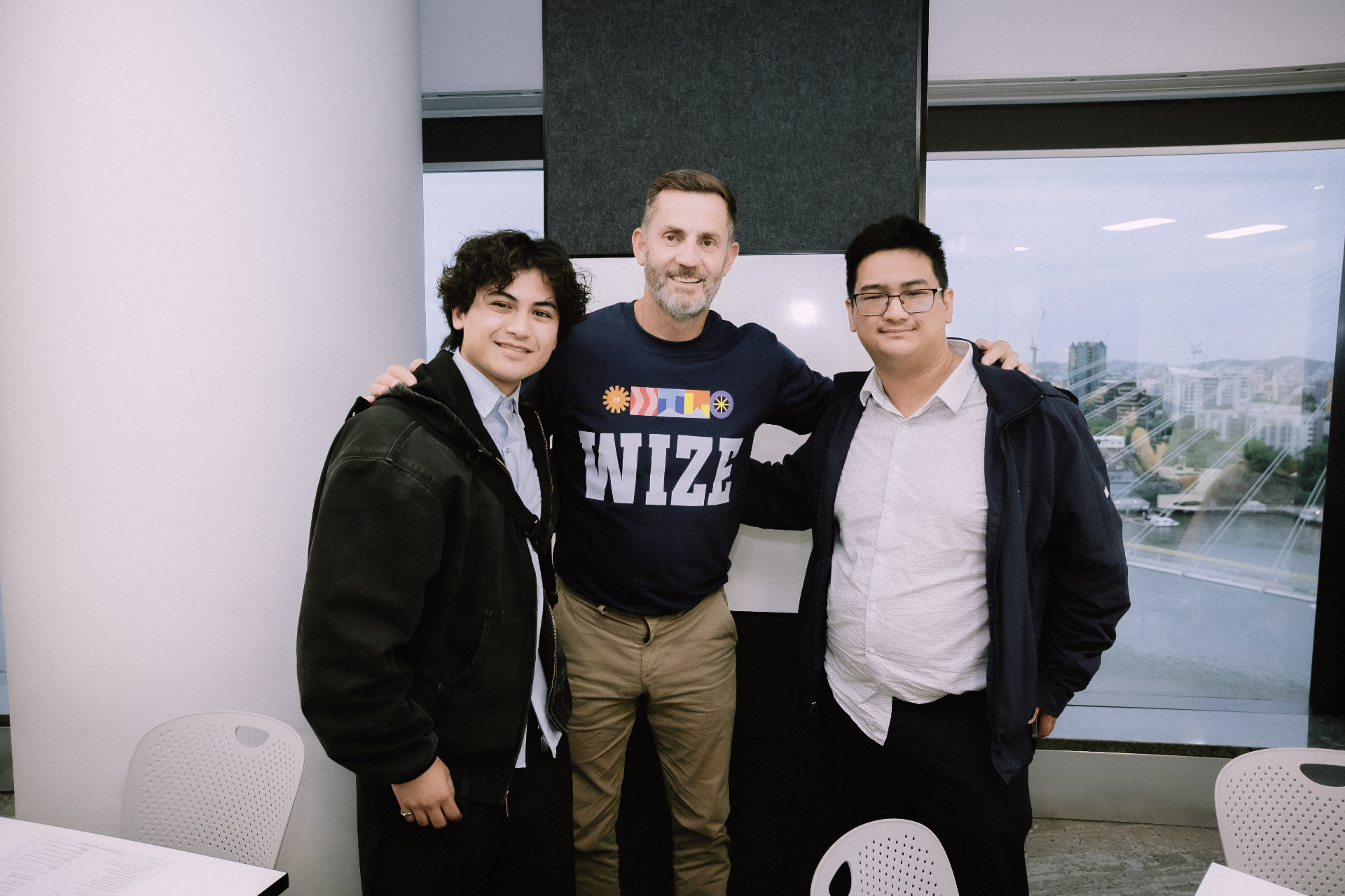 Two young attendees posing with a Wize team member during the Day 4 workshop