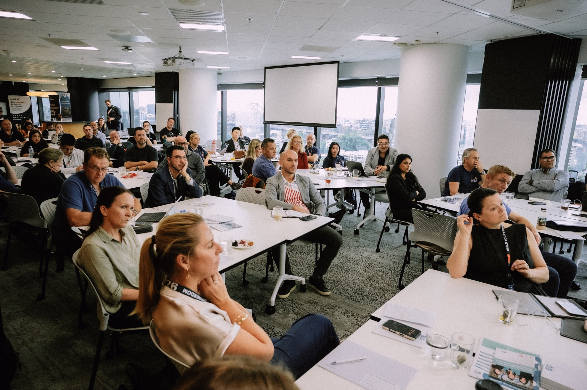 Attendees seated around the workshop room listening closely during the Day 4 intensive