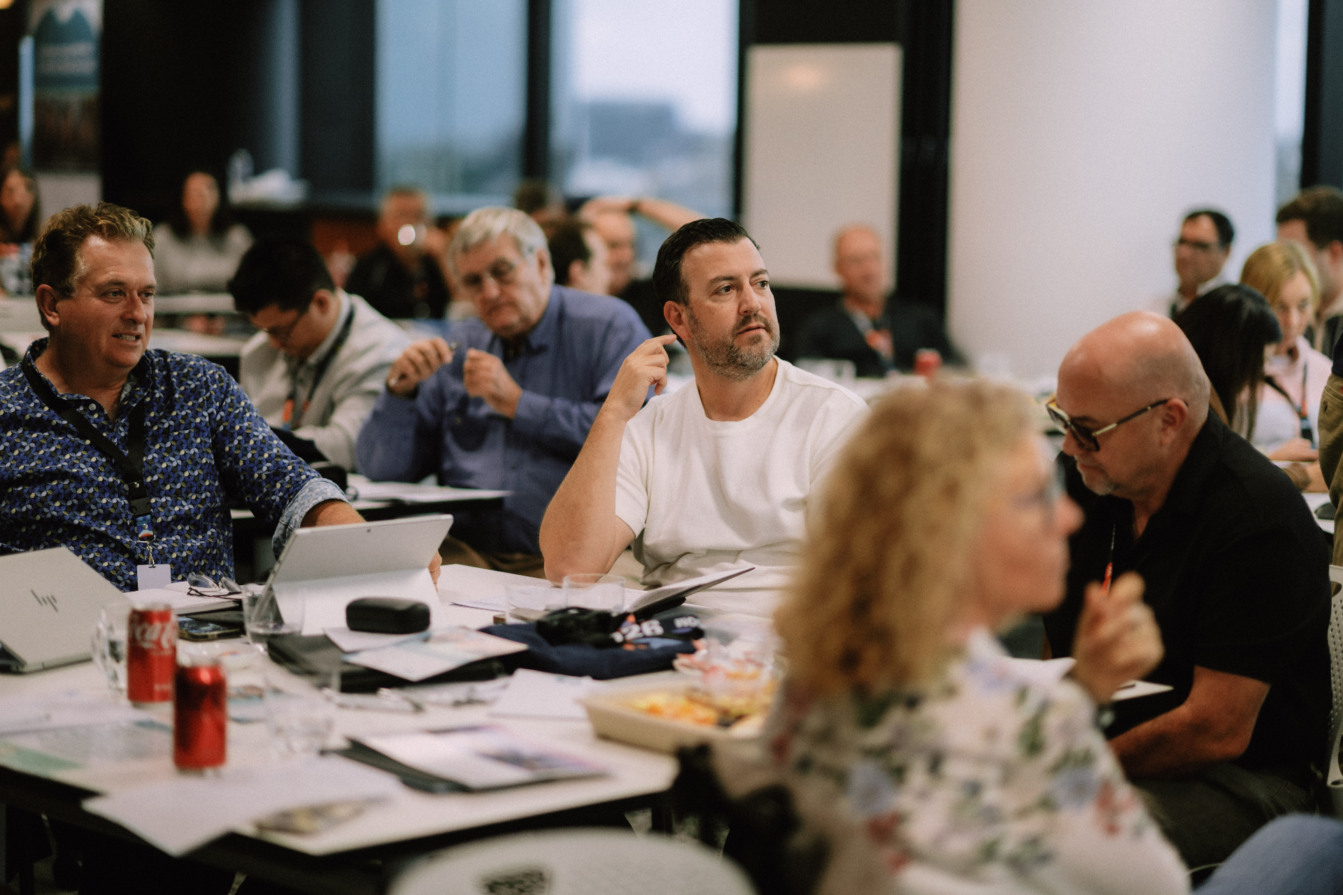 Attendees listening around a workshop table during the May 25 Day 1 session