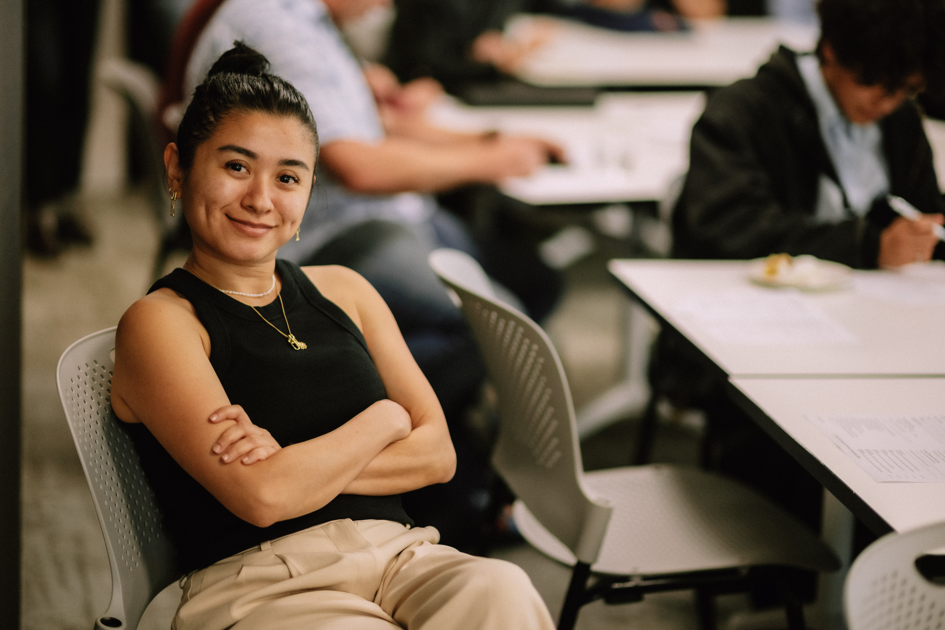 Smiling attendee seated in the workshop room during the Day 4 intensive