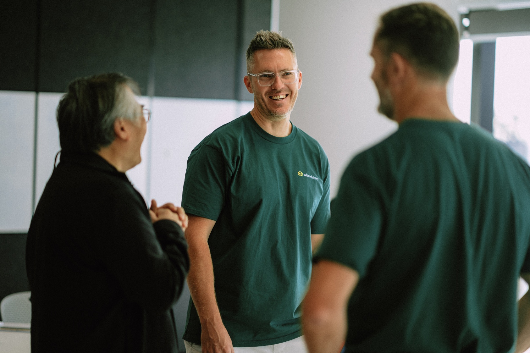 A Wize mentor laughing with firm owners at a workshop