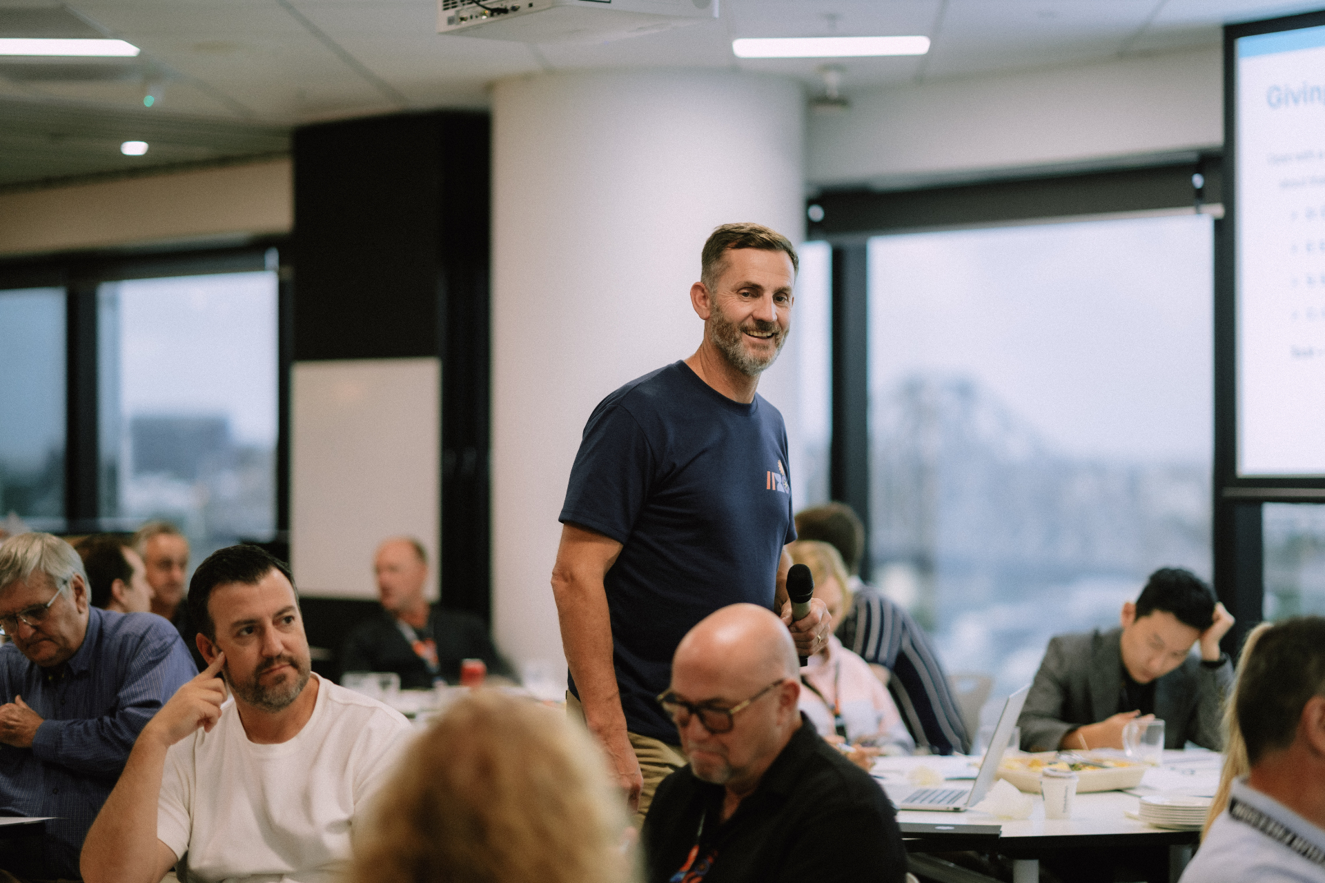 Wize team member standing with a microphone among attendees during the May 25 Day 1 workshop