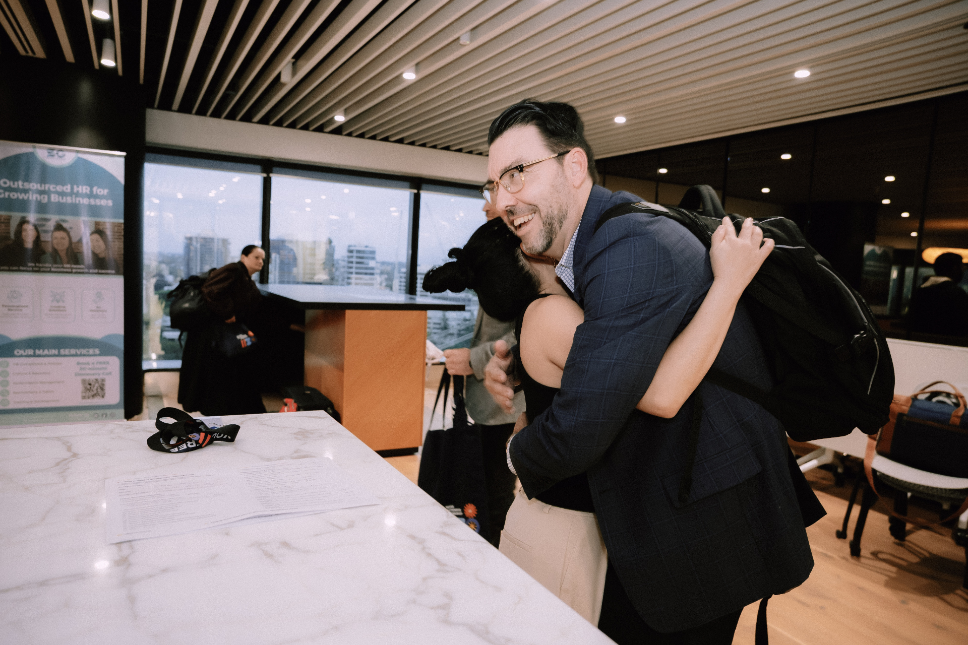 Attendee sharing a warm hug with a Wize team member at the registration desk