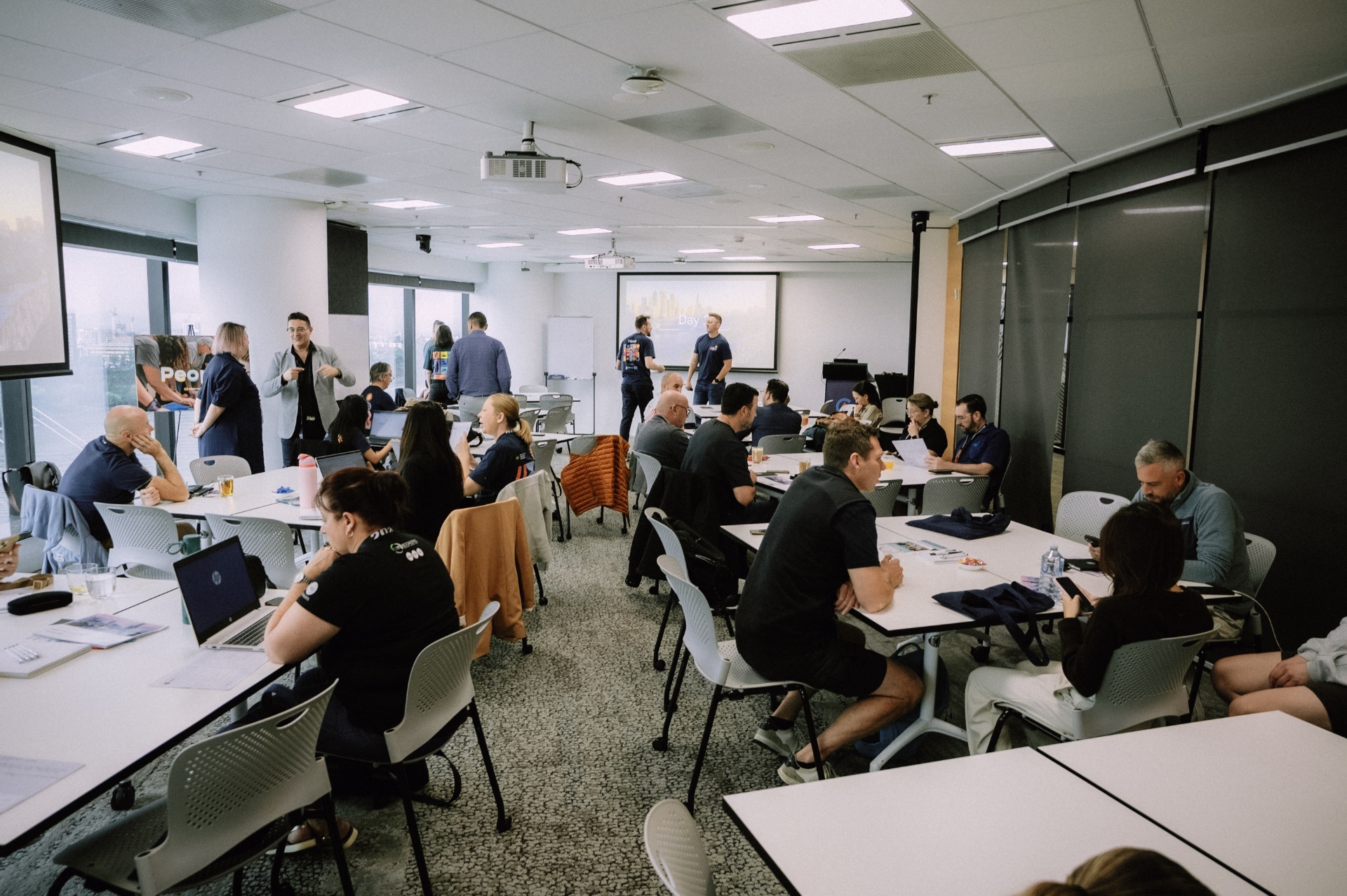 Wide view of the Wize Intensive workshop room as attendees work in table groups