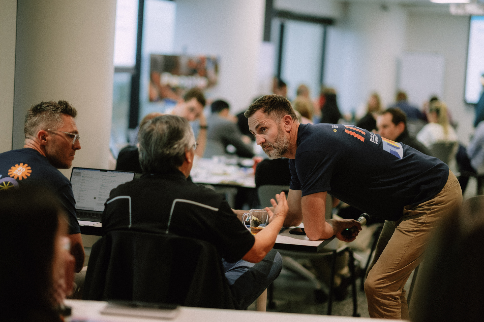 Wize team member in conversation with attendees during a Day 1 workshop break