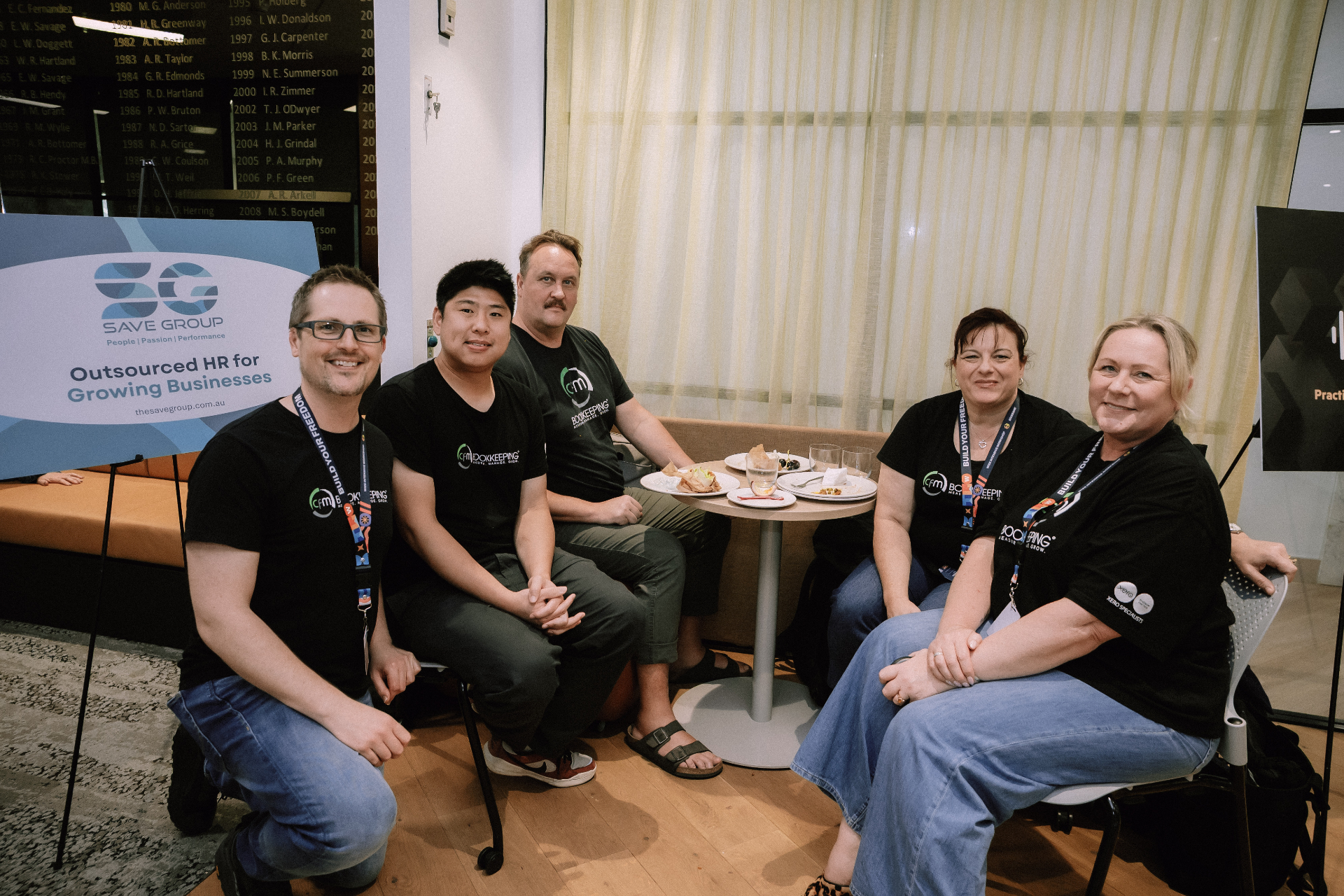 Five workshop attendees seated together for a group photo during a break