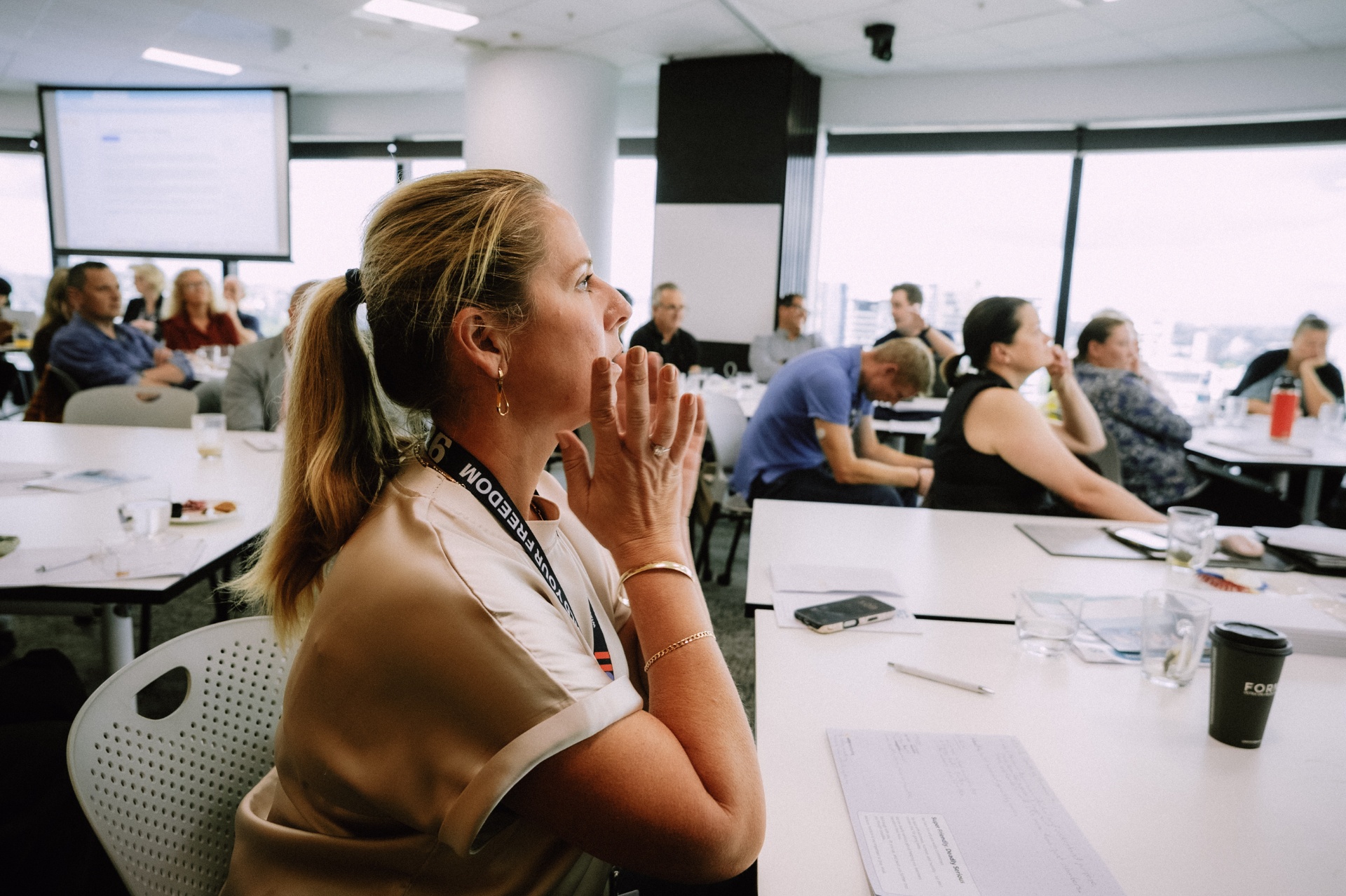 Attendee listening intently with hands clasped during a Day 4 Wize Intensive session