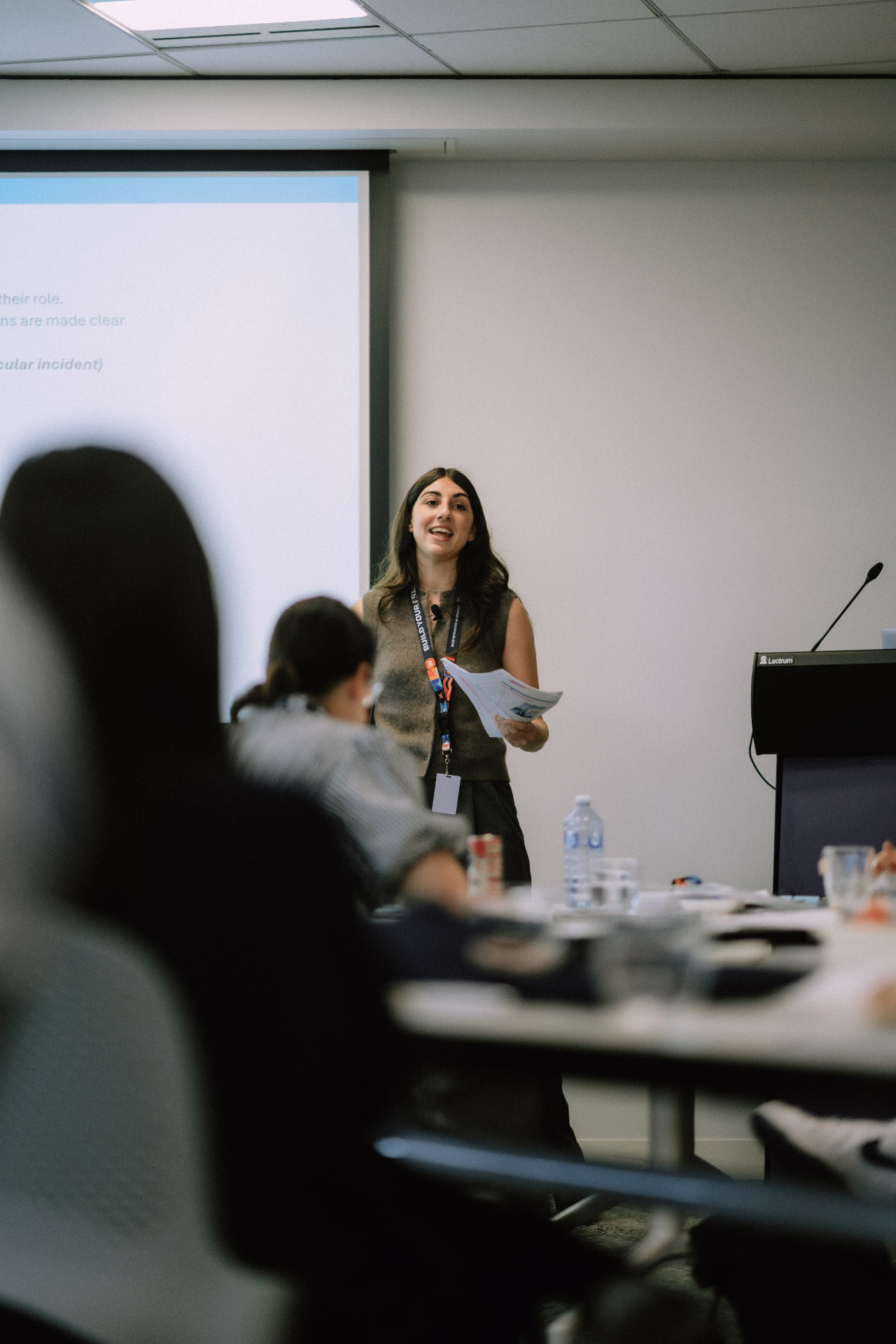 Presenter holding notes while addressing attendees during the May 25 Day 1 workshop