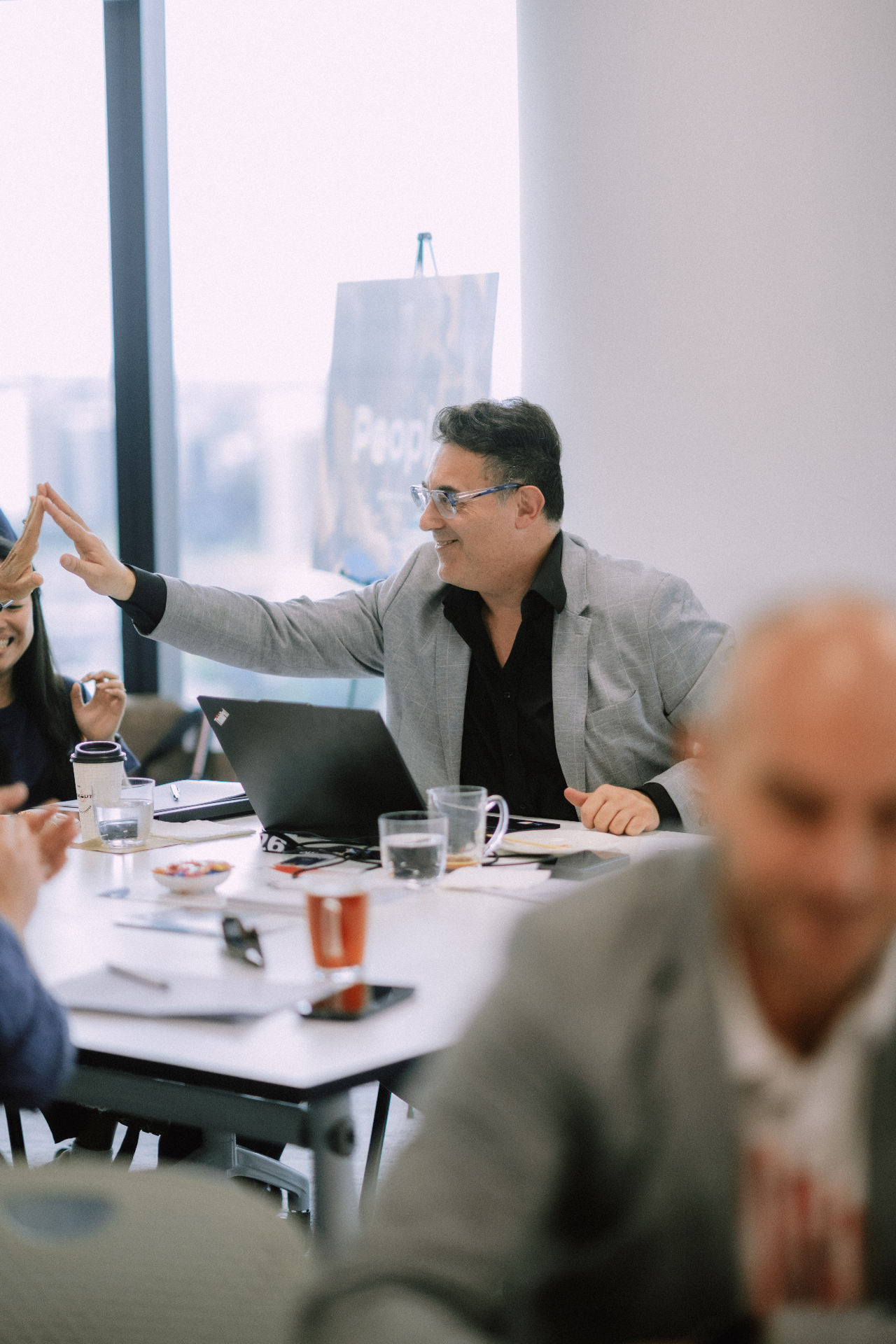 Presenter reaching across the table for a high five during an interactive workshop moment