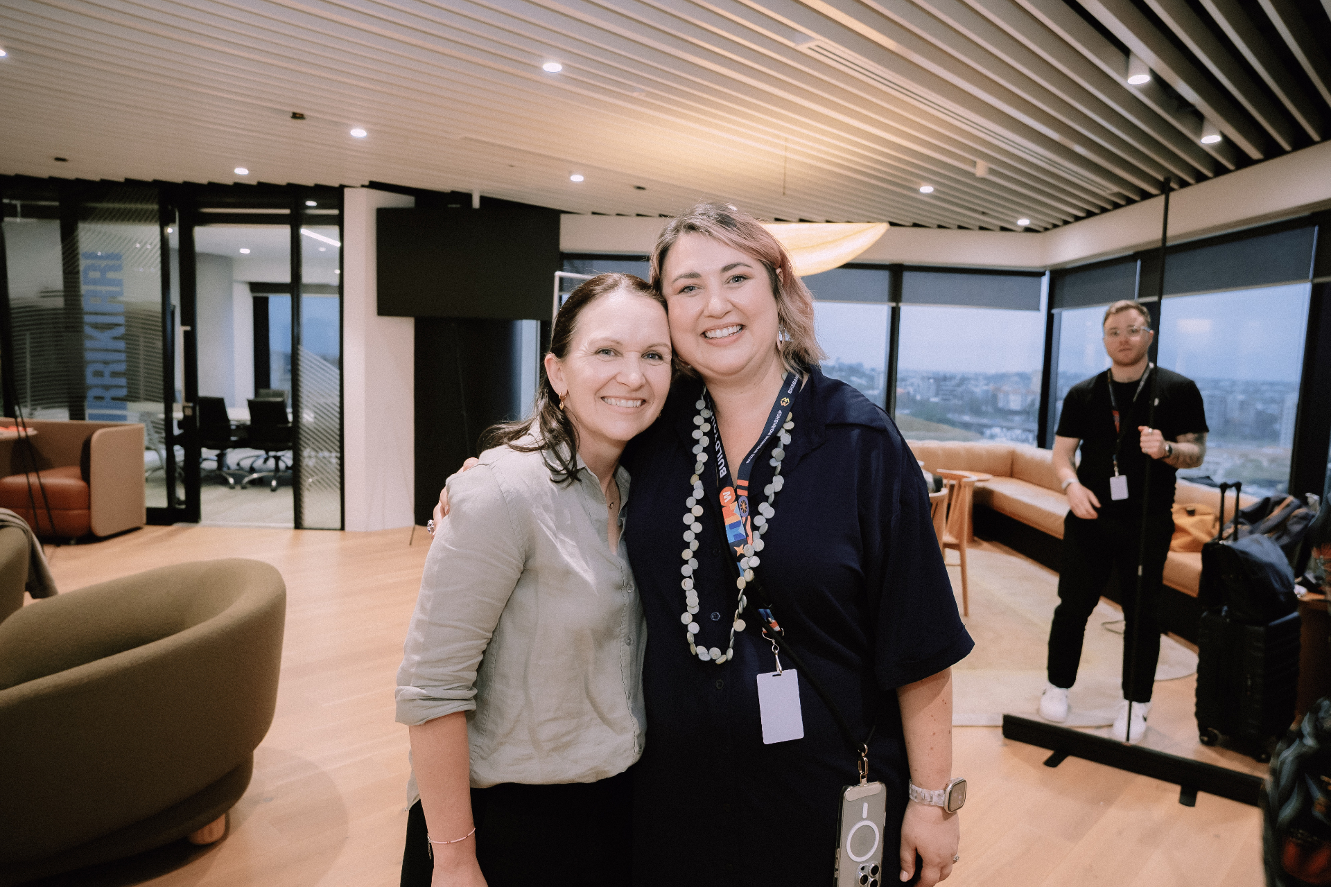 Two attendees smiling together in the networking lounge during the Day 4 event