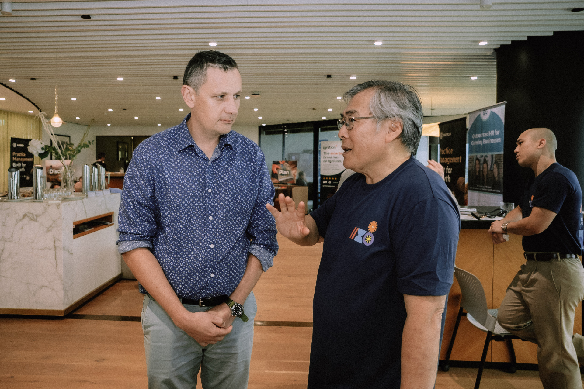 Two attendees in conversation near the networking lounge during the Day 4 workshop