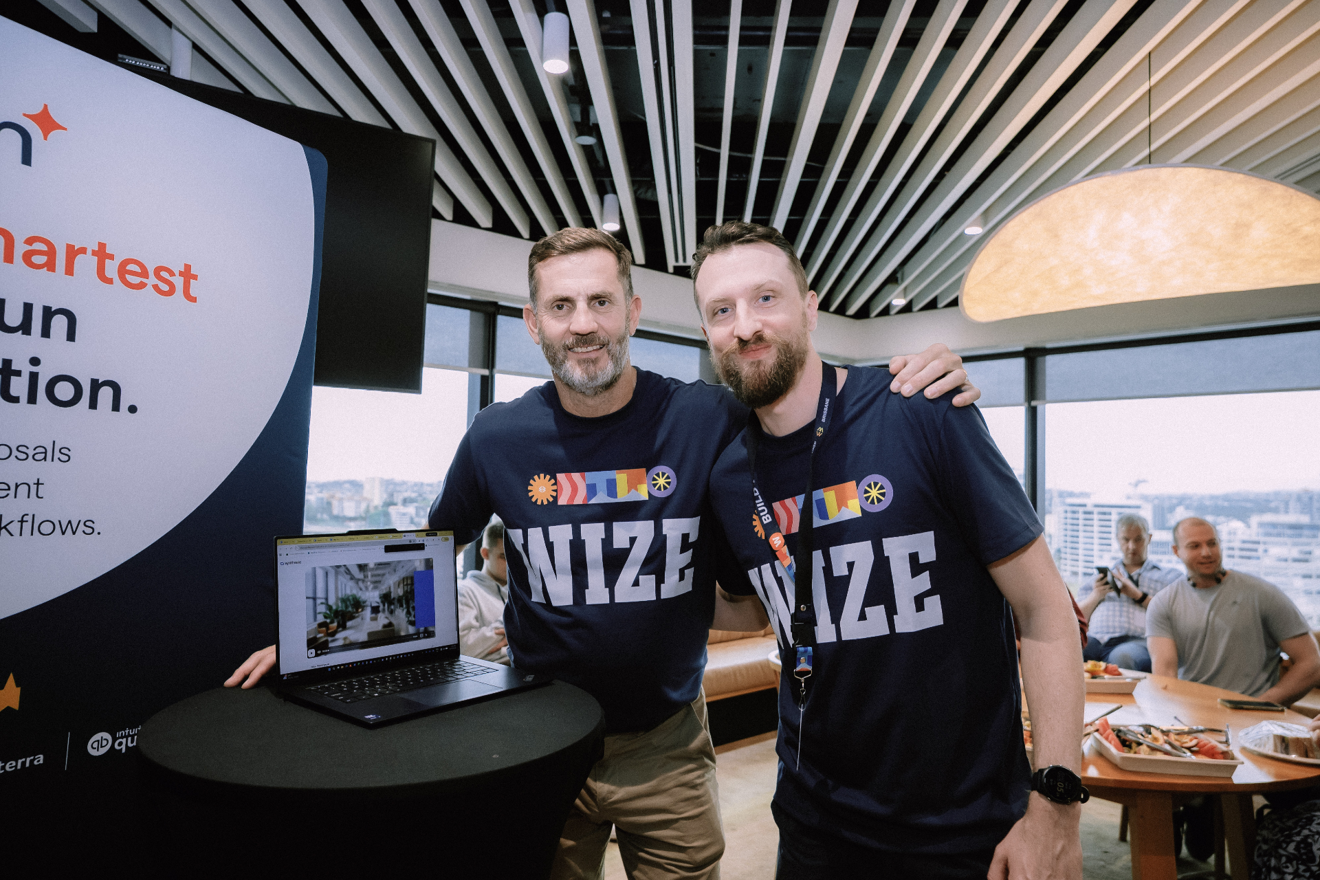 Two Wize team members posing beside a display stand during the Day 4 workshop
