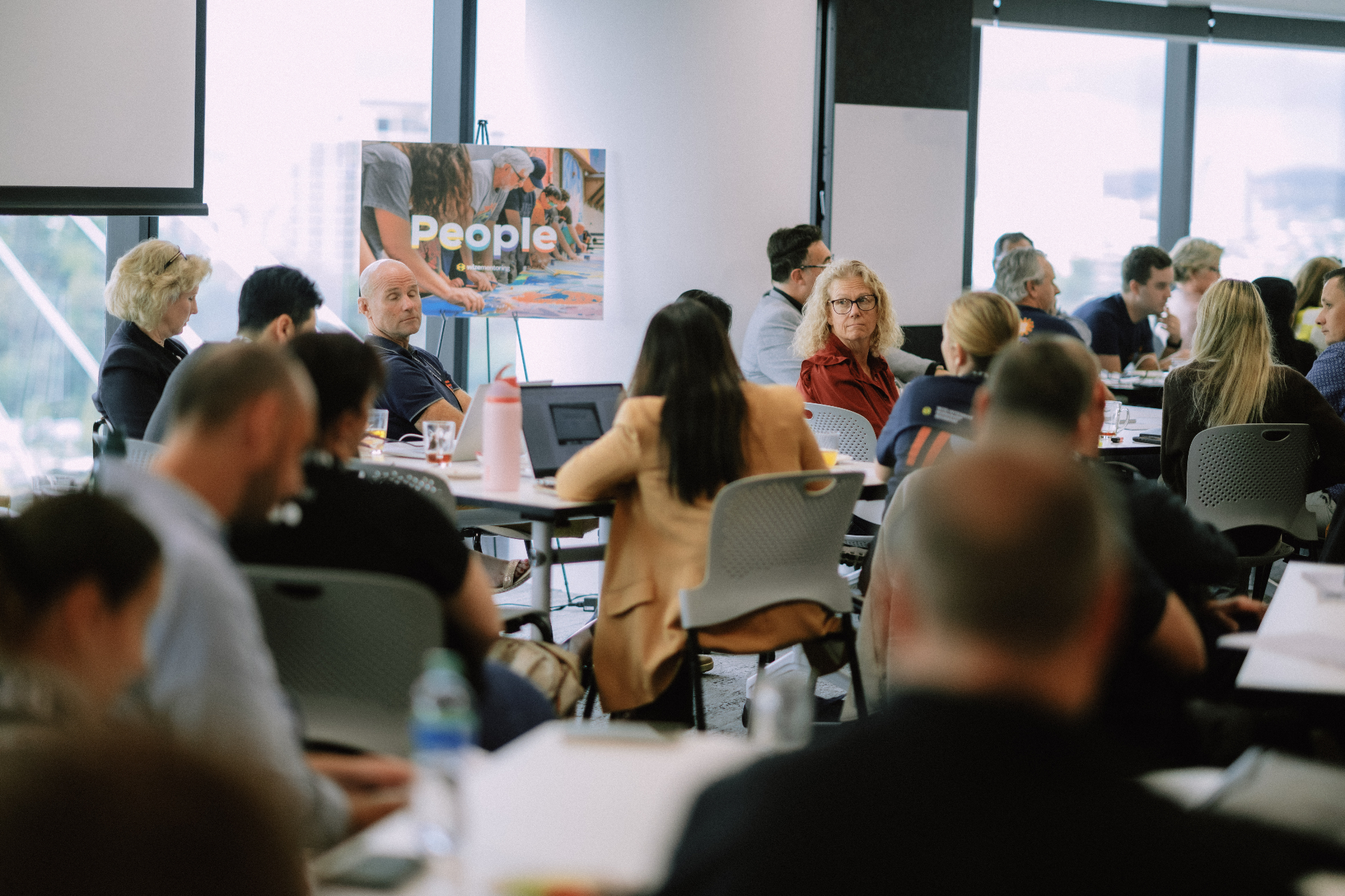Wide view of attendees seated in group discussion during a Day 4 workshop session