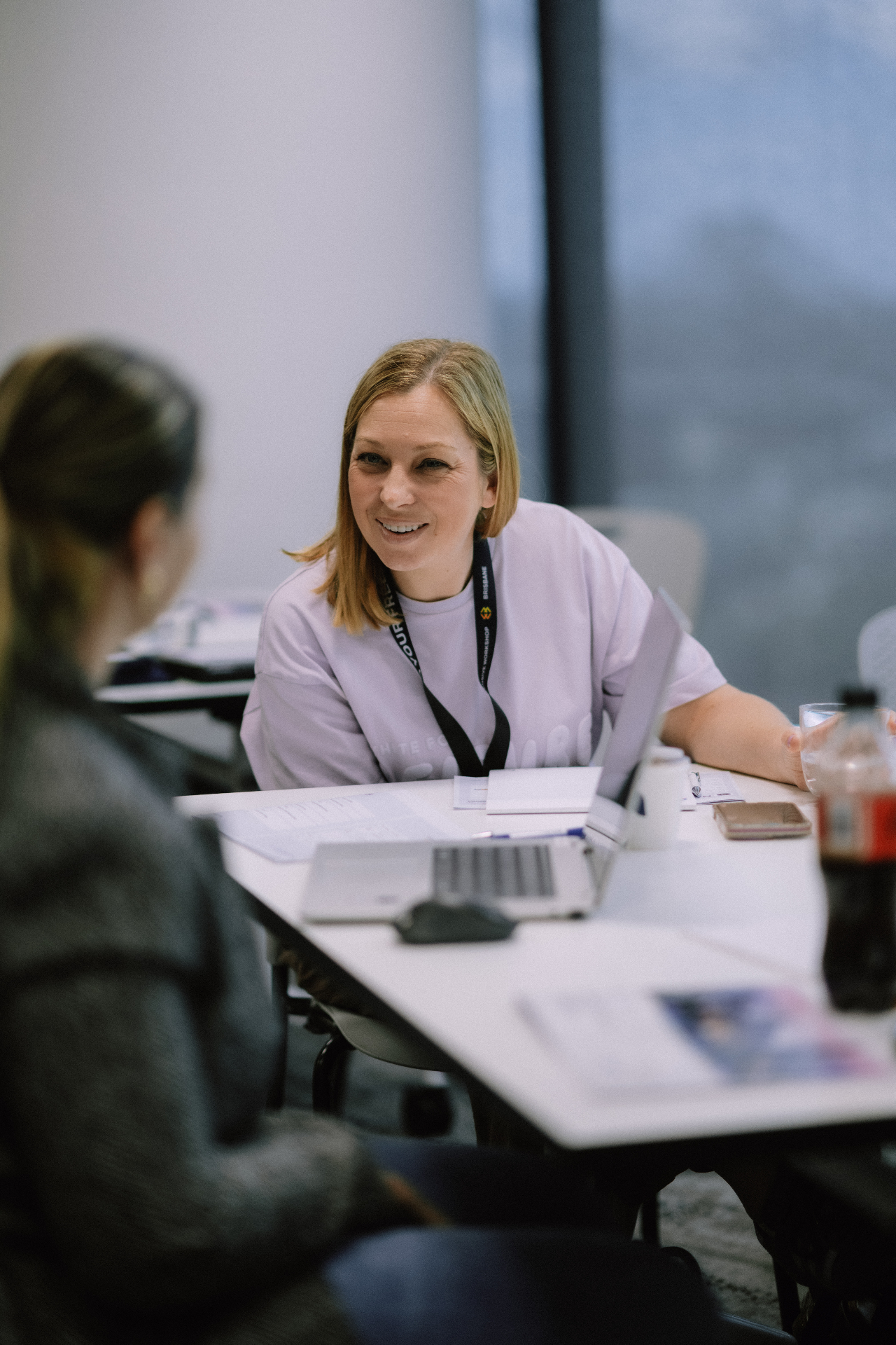 Attendee in conversation across the workshop table during Day 1