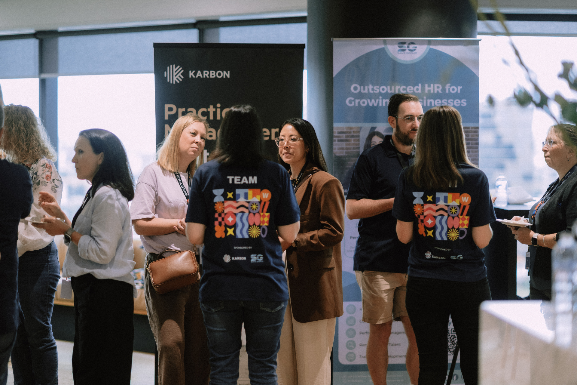 Guests networking near sponsor displays at Day 1 Wize Intensive